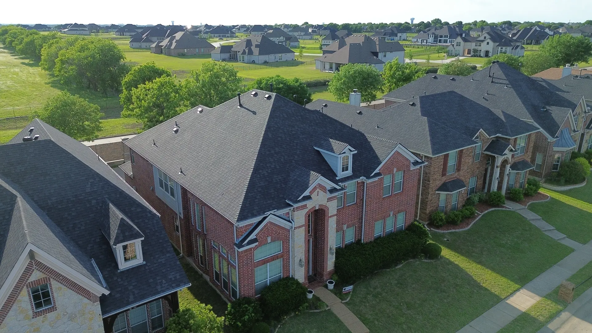 Aerial view of luxury Plano homes with new architectural shingle roofs by IronCrest Construction Group